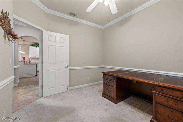 unfurnished office featuring crown molding, sink, light carpet, and ceiling fan