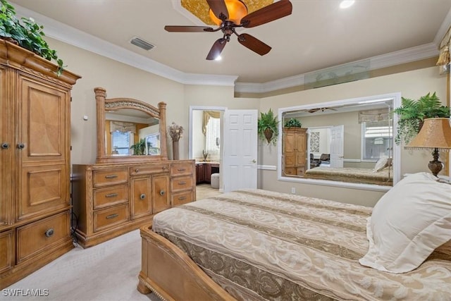 bedroom featuring ornamental molding, light colored carpet, ceiling fan, and ensuite bath