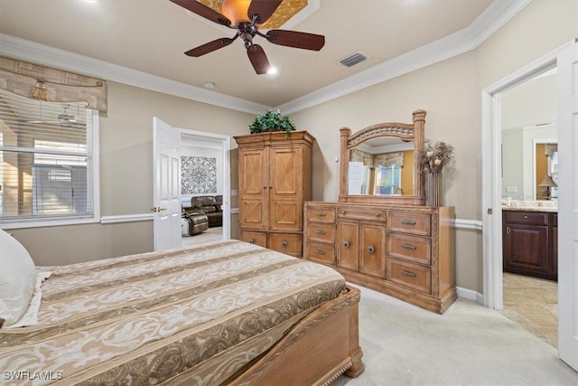 carpeted bedroom with ensuite bath, ornamental molding, and ceiling fan