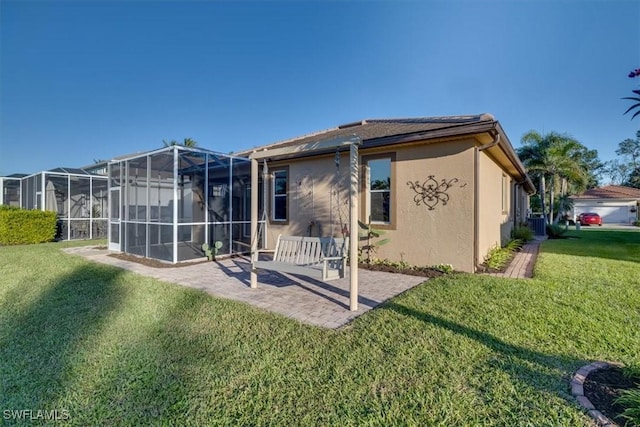 back of house with a patio and a lawn