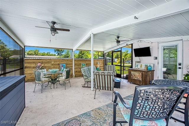 sunroom with lofted ceiling with beams and ceiling fan