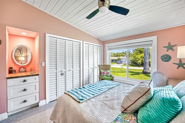 carpeted bedroom featuring multiple closets, ceiling fan, wood ceiling, and lofted ceiling