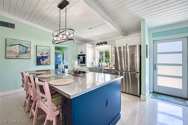 kitchen with pendant lighting, white cabinets, a kitchen island, a kitchen bar, and stainless steel appliances