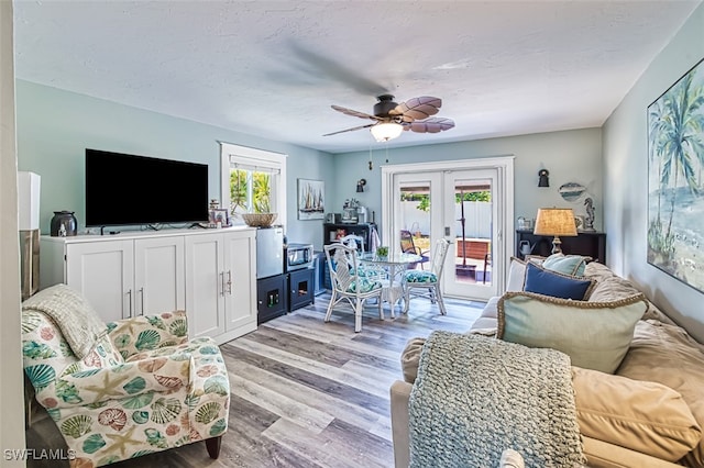 living room featuring french doors, light hardwood / wood-style floors, and ceiling fan