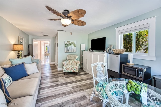 living room featuring ceiling fan and wood-type flooring