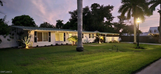 ranch-style home featuring a lawn