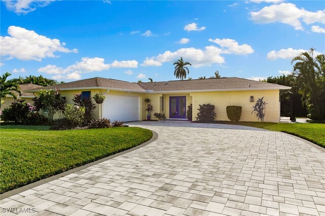 ranch-style home with a garage and a front yard