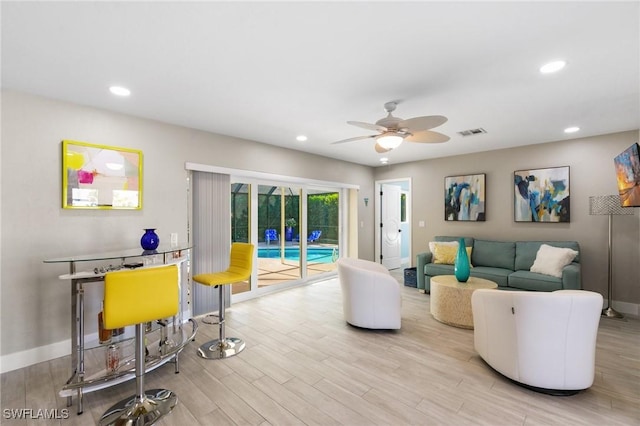 living room with light wood-type flooring and ceiling fan