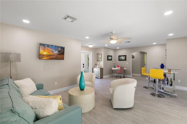 living room featuring ceiling fan and light hardwood / wood-style flooring