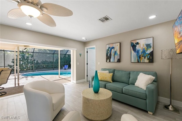 living room with ceiling fan and light hardwood / wood-style flooring