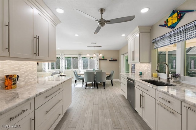 kitchen with ceiling fan, sink, stainless steel dishwasher, decorative backsplash, and white cabinets