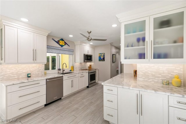 kitchen featuring stainless steel appliances, white cabinetry, ceiling fan, and sink