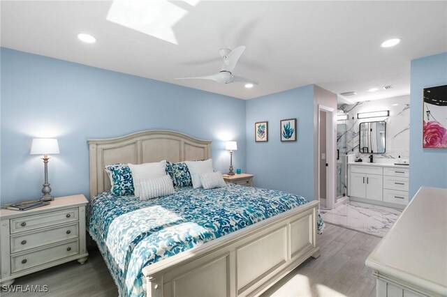 bedroom featuring ensuite bathroom, light hardwood / wood-style flooring, and ceiling fan