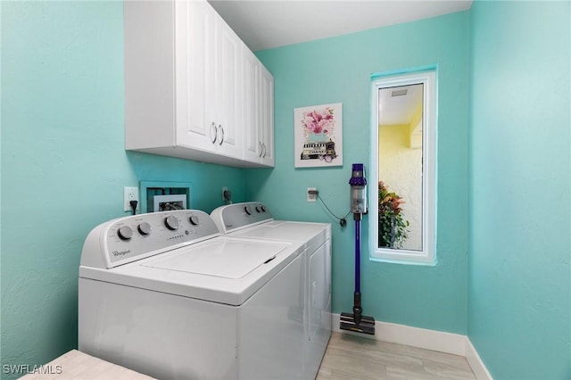 laundry area with washer and dryer and cabinets