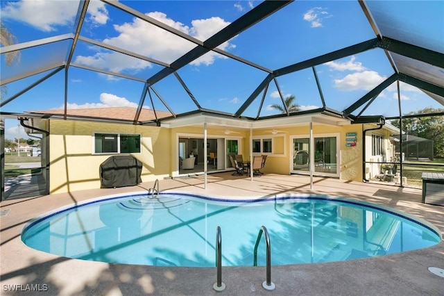 view of pool with ceiling fan, a patio, and glass enclosure