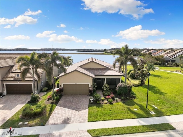 view of front facade with a front lawn, a water view, and a garage