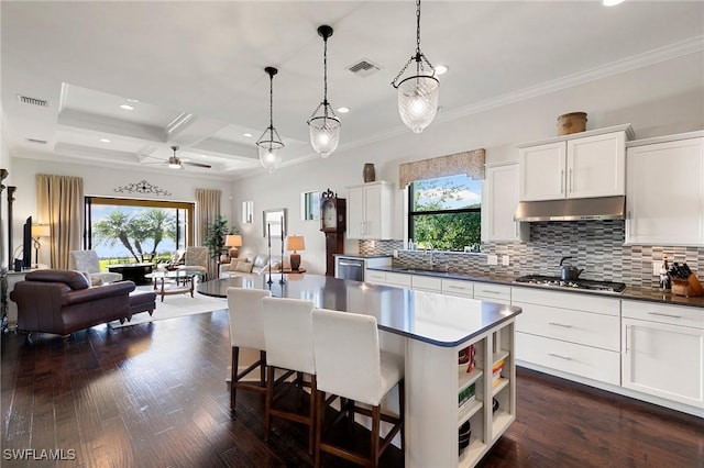 kitchen featuring stainless steel gas stovetop, coffered ceiling, hanging light fixtures, beam ceiling, and white cabinetry