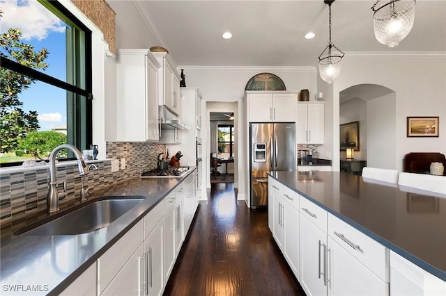 kitchen featuring pendant lighting, backsplash, white cabinets, sink, and stainless steel appliances