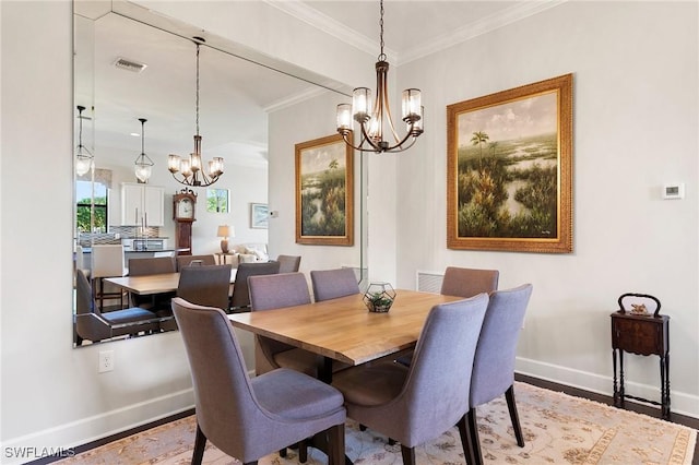 dining room featuring crown molding, hardwood / wood-style flooring, and a notable chandelier