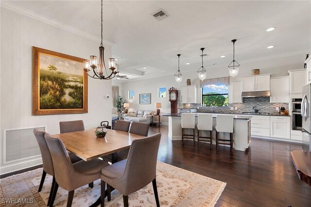 dining space with a chandelier, dark hardwood / wood-style floors, and ornamental molding