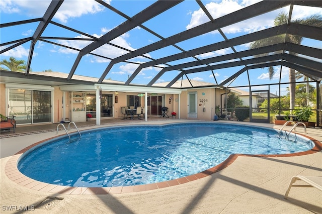 view of swimming pool featuring glass enclosure and a patio area