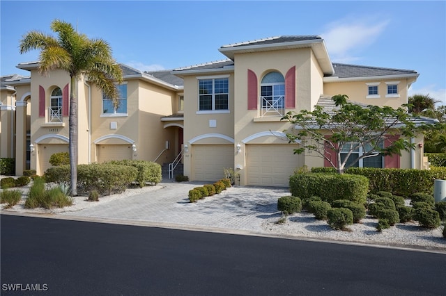 view of front of home featuring a garage, decorative driveway, and stucco siding