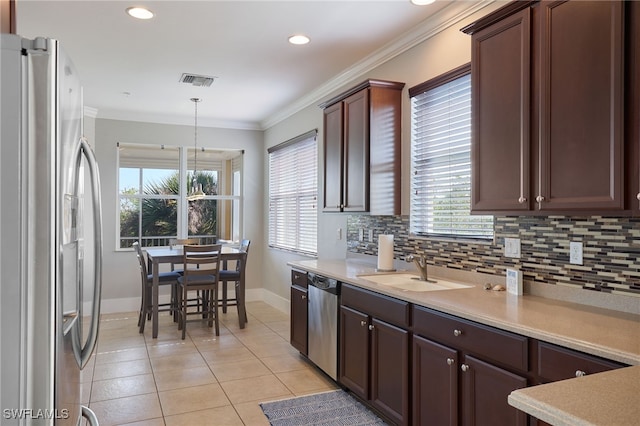 kitchen with sink, hanging light fixtures, decorative backsplash, light tile patterned flooring, and stainless steel appliances