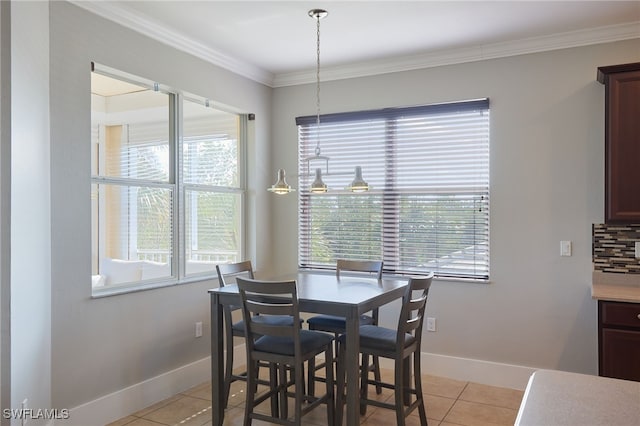 tiled dining space with ornamental molding and a healthy amount of sunlight