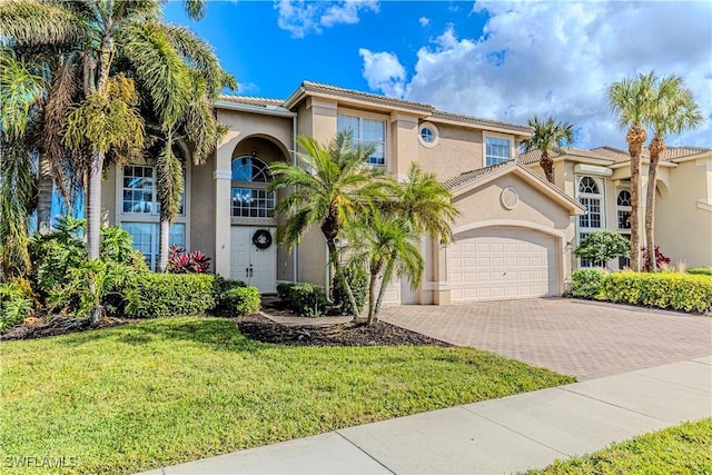 mediterranean / spanish-style home with a front lawn and a garage