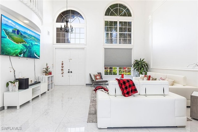 living room with a towering ceiling and a chandelier