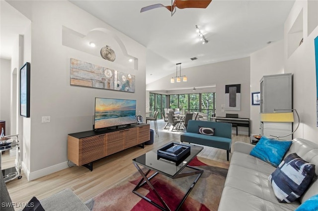 living room featuring ceiling fan, light hardwood / wood-style floors, and lofted ceiling