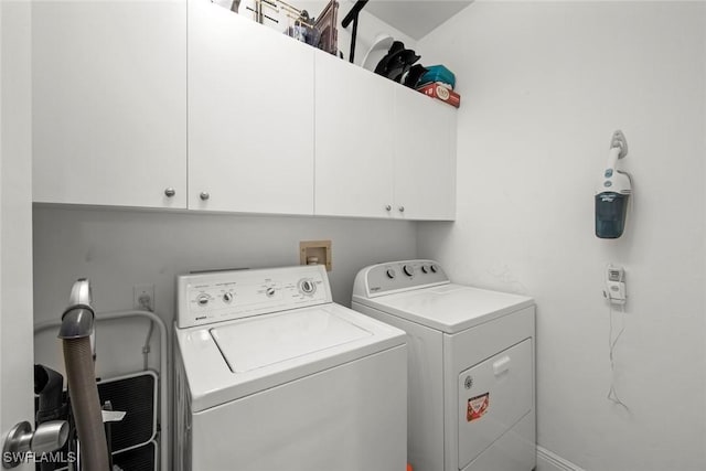 laundry area with washing machine and dryer and cabinets