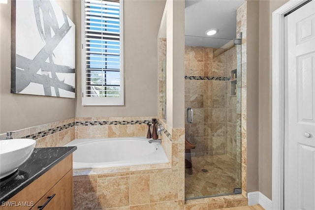 bathroom featuring vanity and shower with separate bathtub