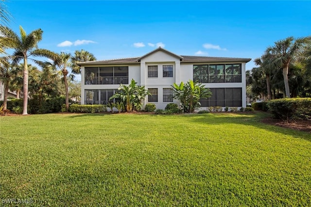 back of property featuring a lawn and a sunroom