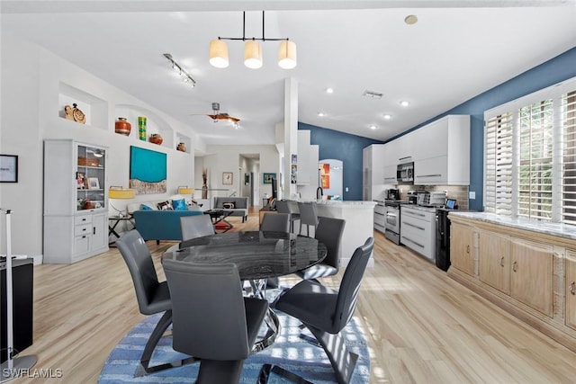 dining area with light hardwood / wood-style flooring and vaulted ceiling