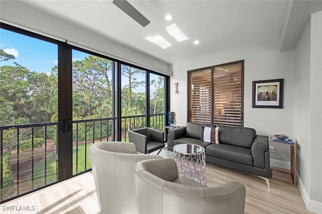 living room featuring light wood-type flooring and ceiling fan