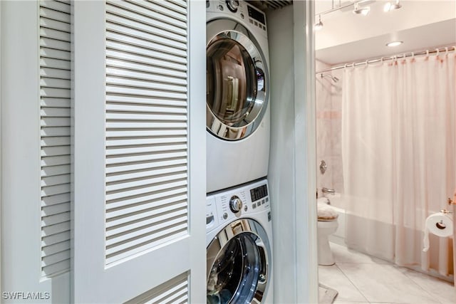 laundry room with stacked washer / drying machine and light tile patterned floors