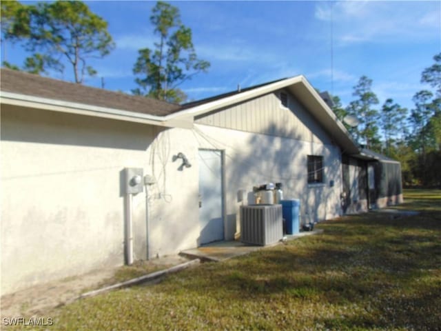 view of home's exterior with central AC unit and a lawn