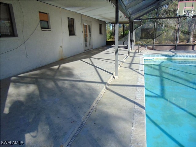 view of pool featuring french doors, a patio, and glass enclosure