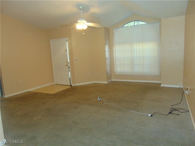 carpeted spare room with ceiling fan and lofted ceiling