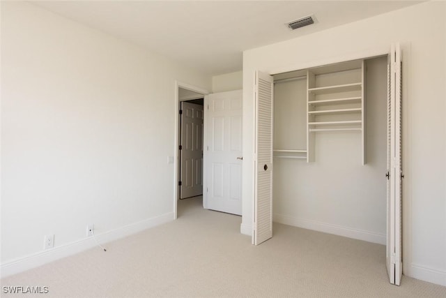 unfurnished bedroom featuring a closet and light carpet