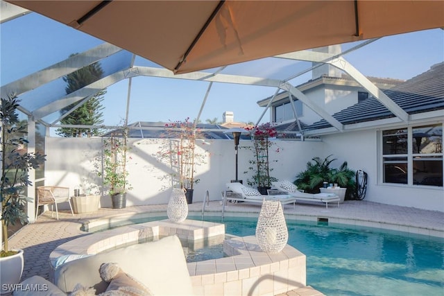 view of pool with a lanai, a hot tub, and a patio