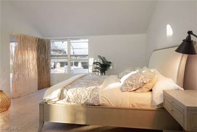 bedroom featuring lofted ceiling and hardwood / wood-style flooring