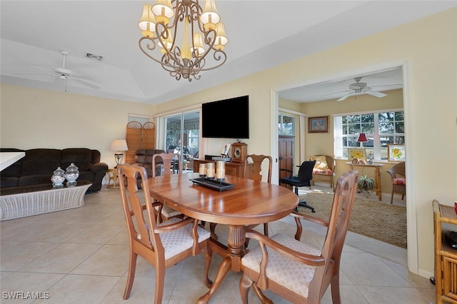 tiled dining room featuring ceiling fan with notable chandelier and a raised ceiling