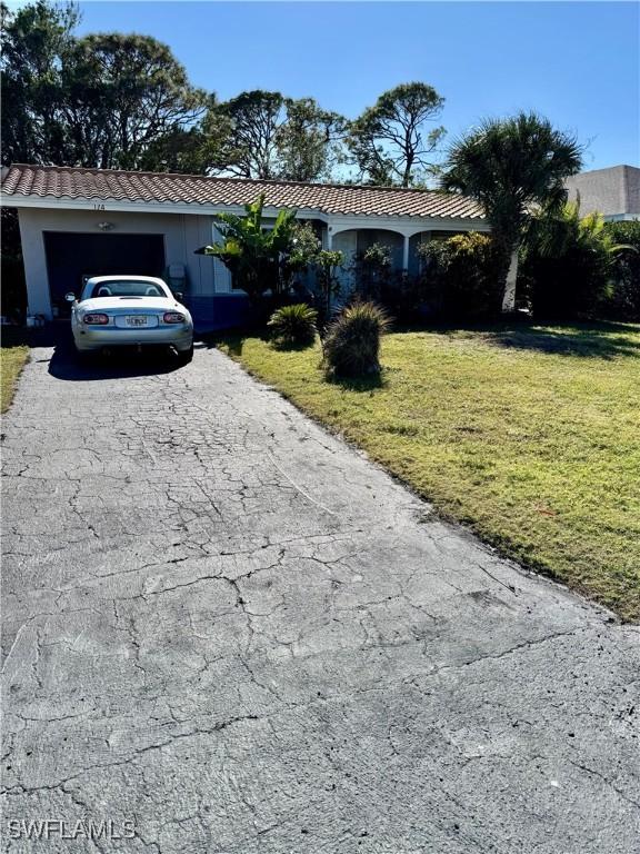 ranch-style house featuring a front lawn and a garage