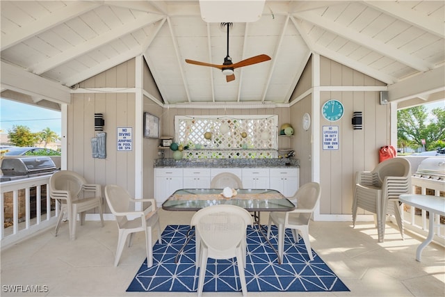 dining space with lofted ceiling with beams, wooden walls, wood ceiling, and a ceiling fan