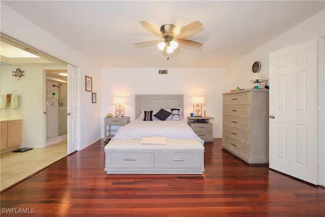 bedroom with dark wood-type flooring and connected bathroom