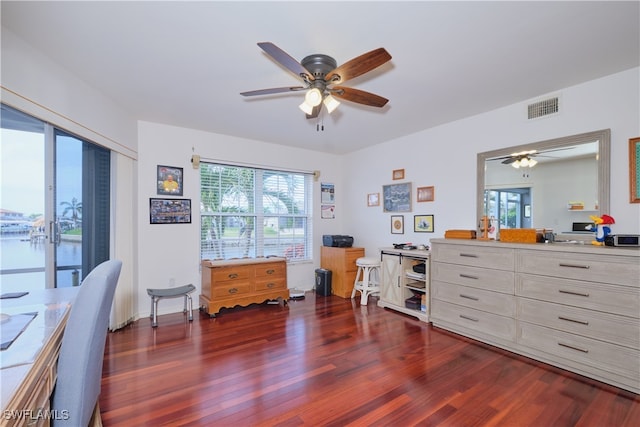 office area featuring ceiling fan, a water view, and dark hardwood / wood-style flooring