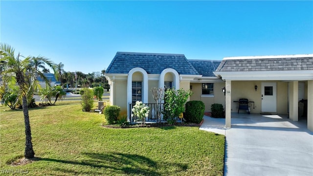 view of front of home with a front lawn and a carport