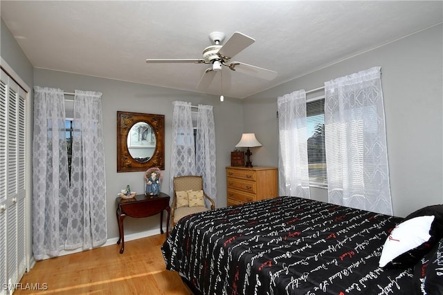 bedroom with a closet, hardwood / wood-style flooring, and ceiling fan